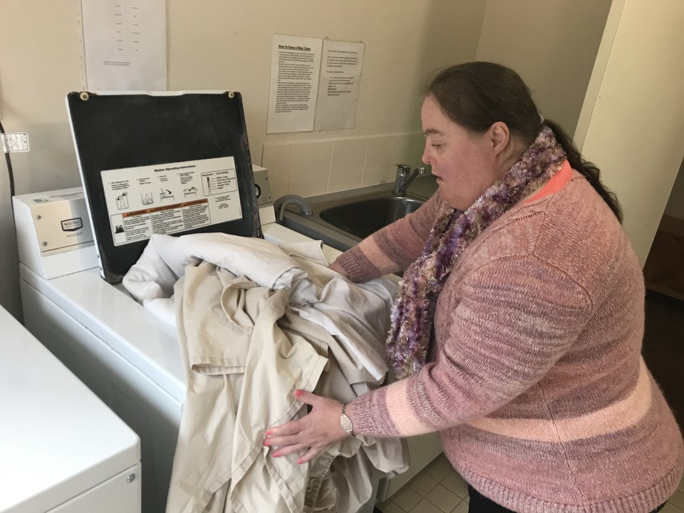 a woman standing in front of a washer and dryer