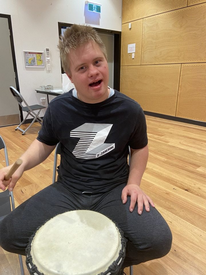 a man sitting on a chair with a drum