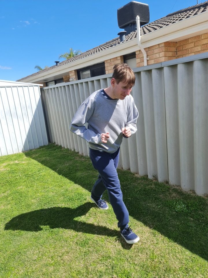 a young boy is running in a yard