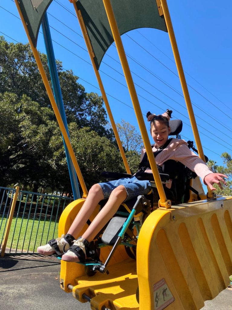 a young girl riding a roller coaster at a park