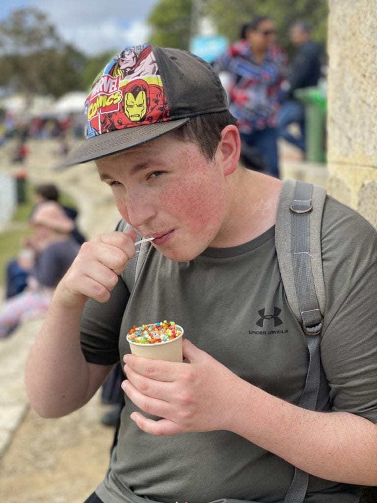 a boy eating an ice cream cone with a straw in his mouth