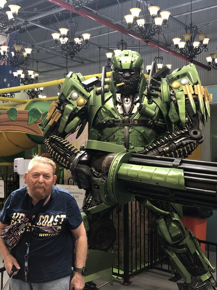 a man standing next to a giant robot
