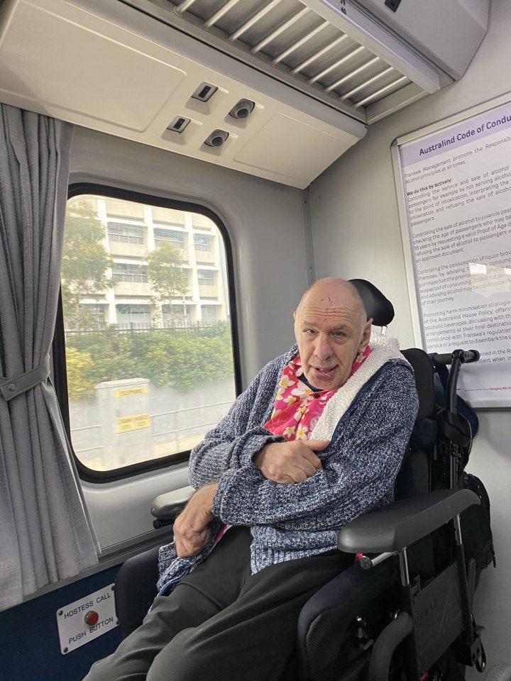 a man sitting in a wheel chair on a train