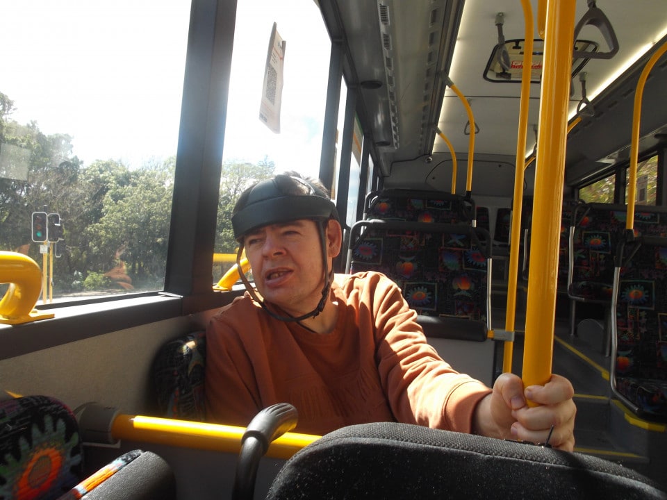a man sitting on a bus with a hat on