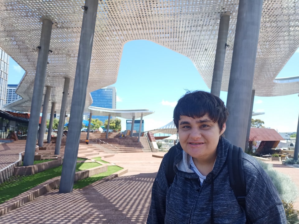 a young man standing under a canopy in front of a building