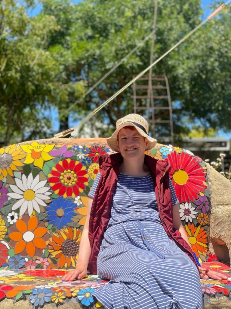 a woman sitting on top of a colorful bench