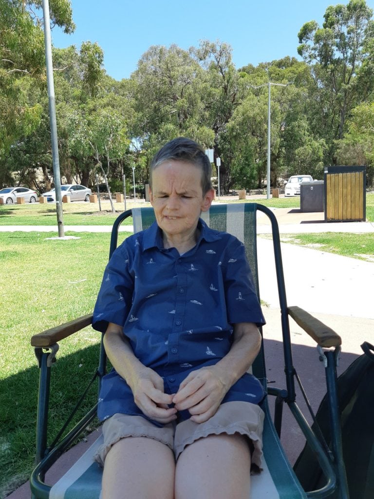 a woman sitting in a chair in a park