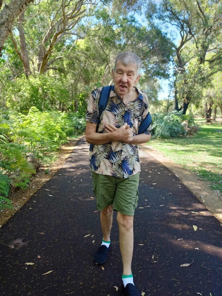 a man walking down a path in a park