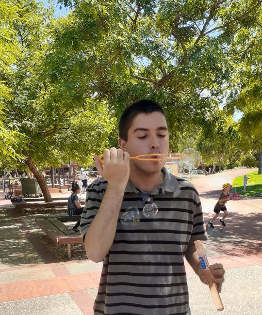 a man blowing bubbles with a stick in his mouth