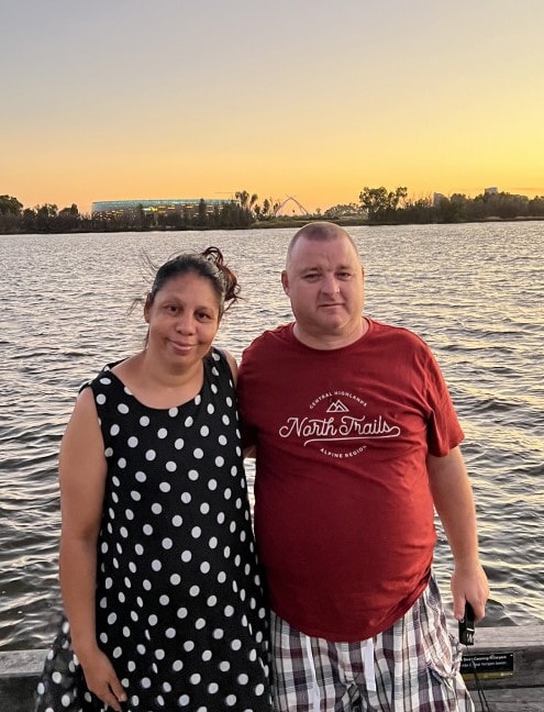 a man and a woman standing next to a body of water