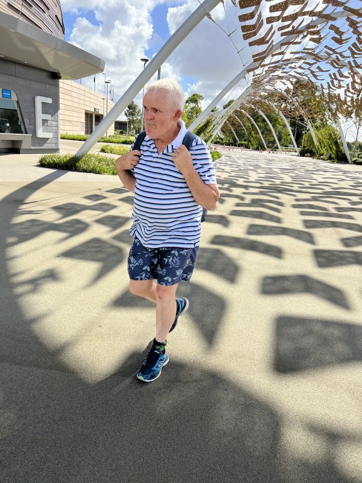 an older man running in front of a building