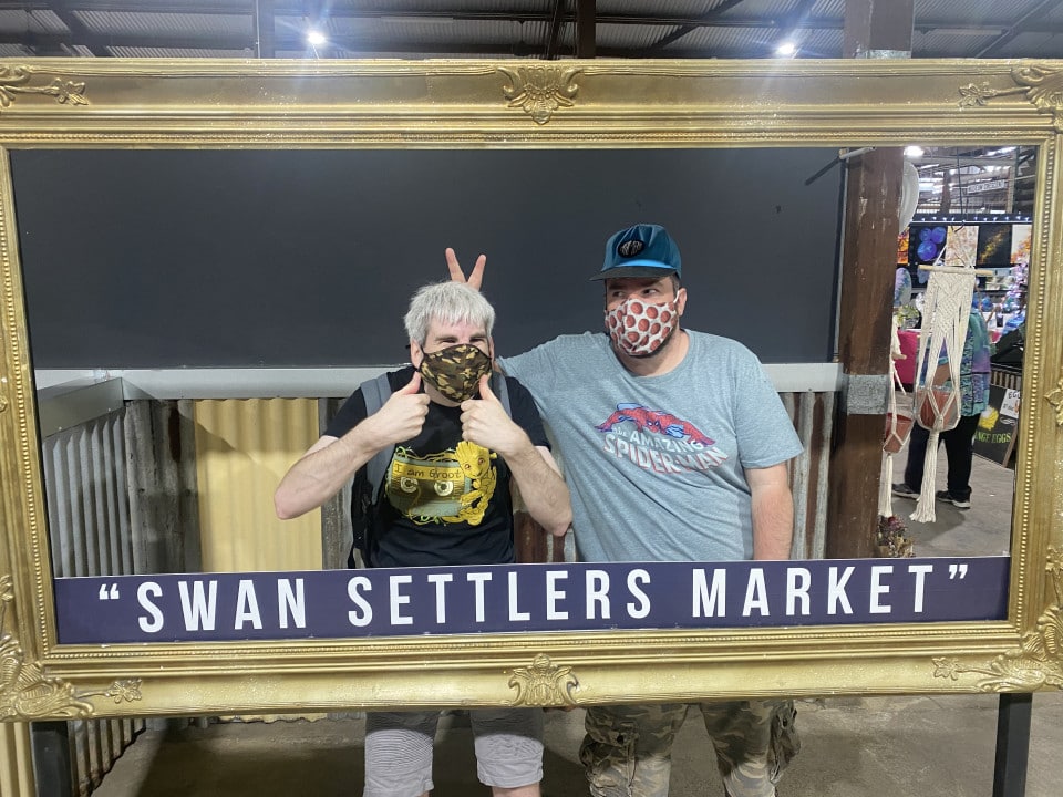 two people standing behind a picture frame