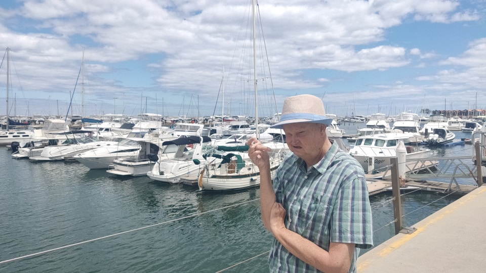 a man standing on a dock next to a bunch of boats