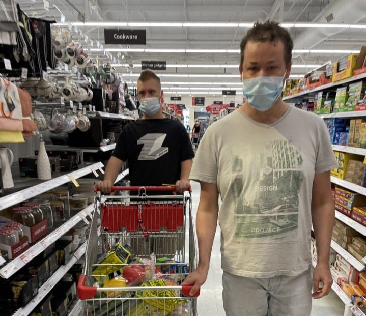 a man wearing a face mask while shopping in a grocery store