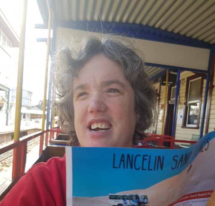 a woman holding up a book with a picture of a bus on it