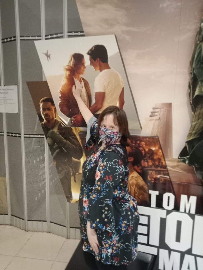 a woman standing in front of a movie poster