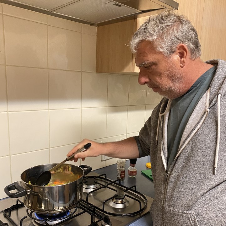 a man cooking food on a stove in a kitchen