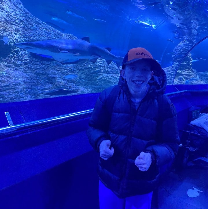 a man standing in front of a large aquarium