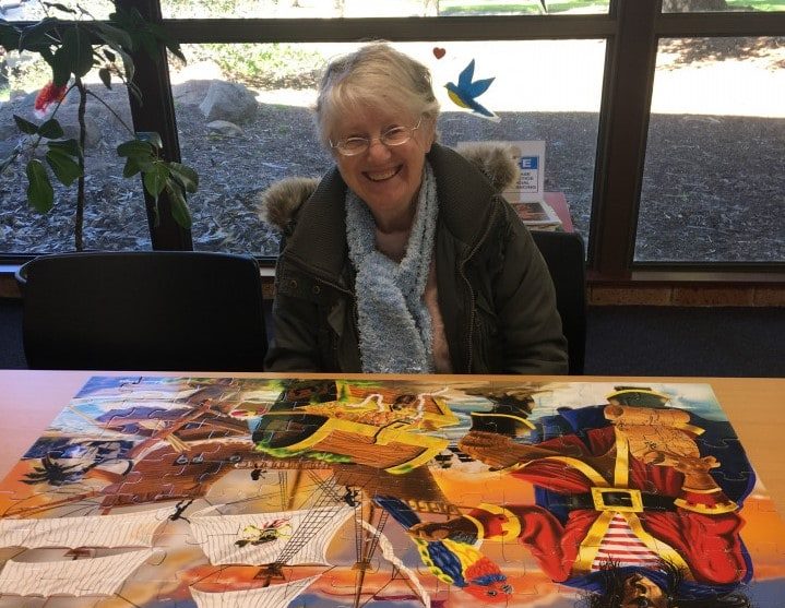 a woman sitting at a table with a puzzle on it