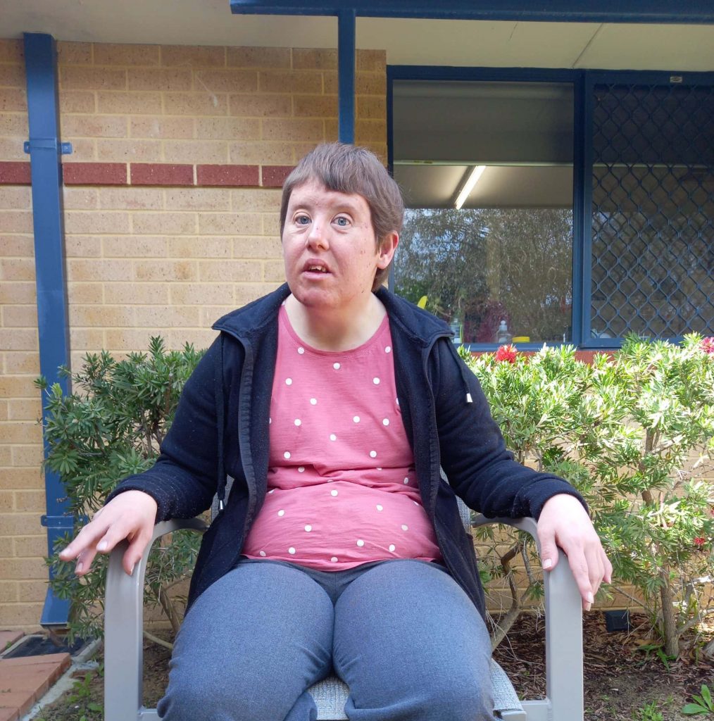 a woman sitting in a chair outside of a building