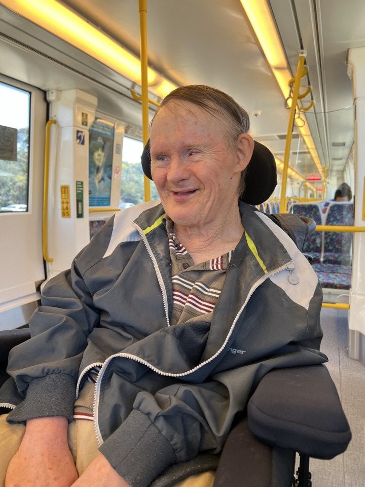 a man sitting in a wheel chair on a train