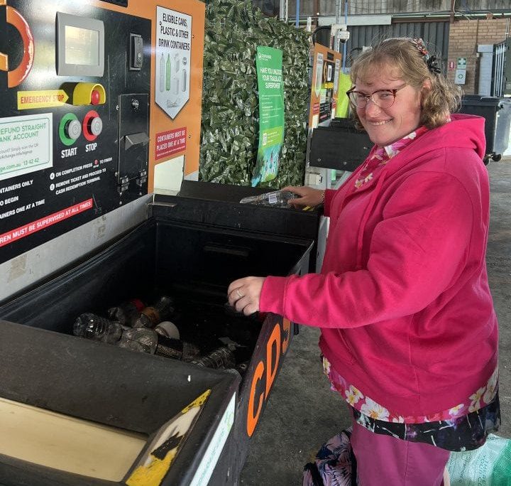 a woman in a pink jacket is doing recycling