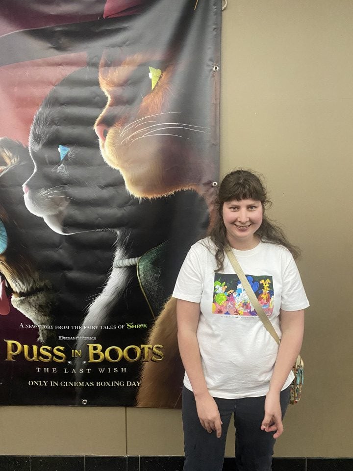 a girl standing in front of a movie poster