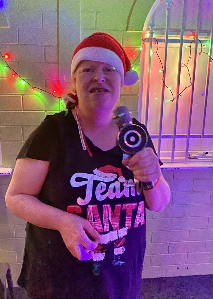 a woman in a santa hat holding a microphone