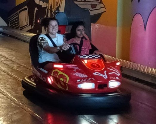 two girls riding a bumper car at a carnival