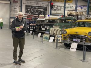 a man standing in front of cars in an exhibition.